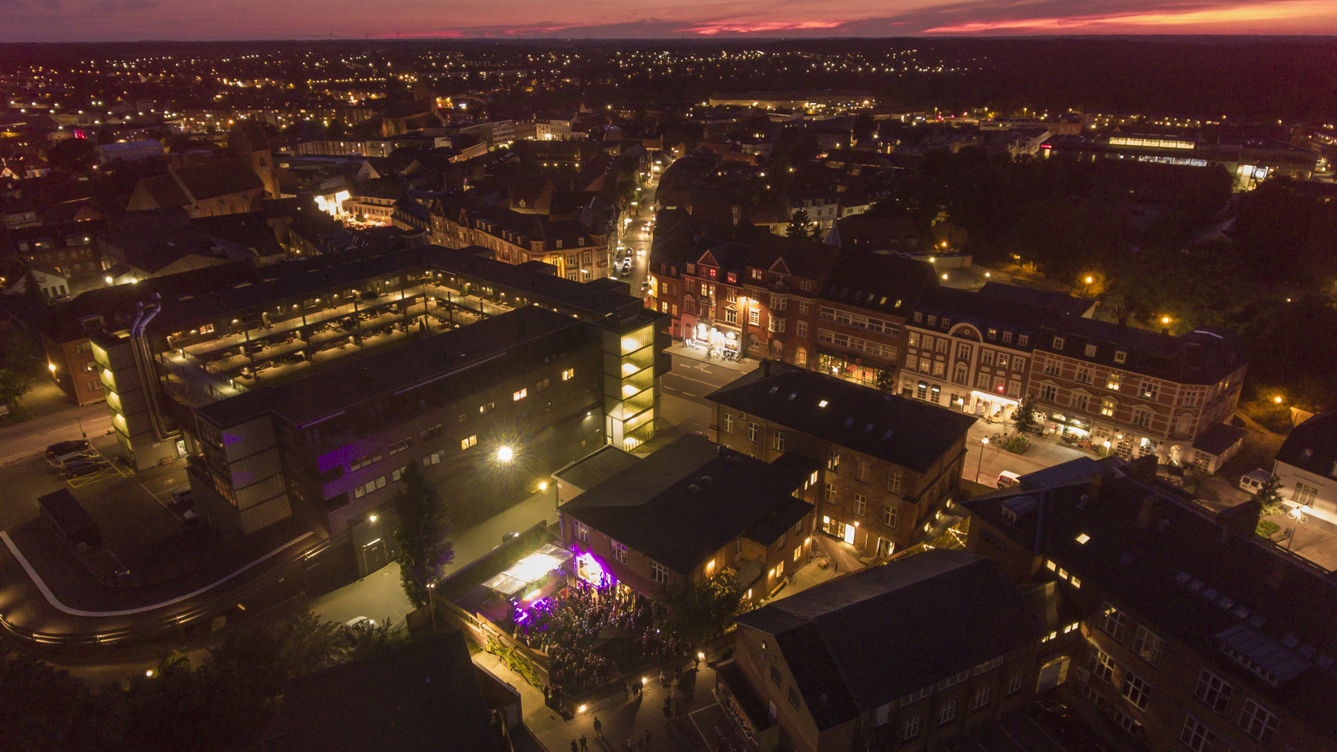 Luftfoto af Næstved om aftenen med alle de flotte lys